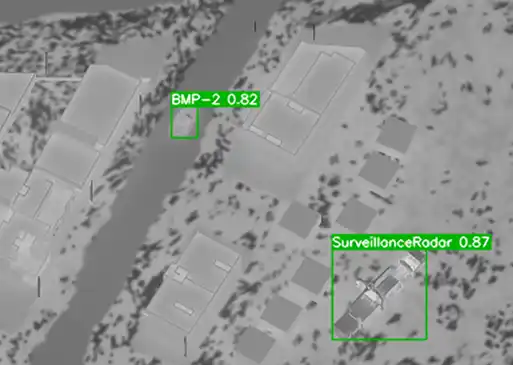 Aerial infrared image with detected and labeled military assets near buildings.