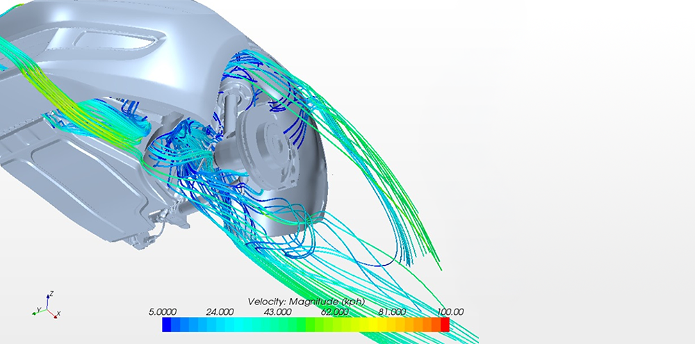Close-up CFD visualization of airflow around a vehicle wheel and brake assembly with colored velocity streamlines.